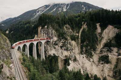 Panoramic shot of bridge amidst trees and mountains