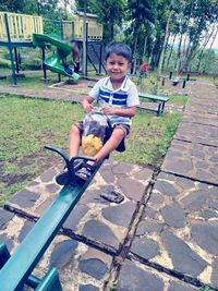 Full length of boy sitting on seat