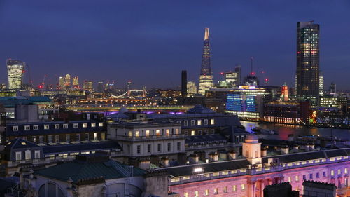 Illuminated buildings in city against sky at night