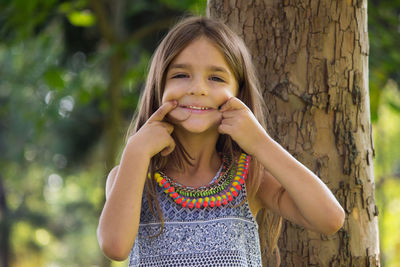 Portrait of smiling girl against tree