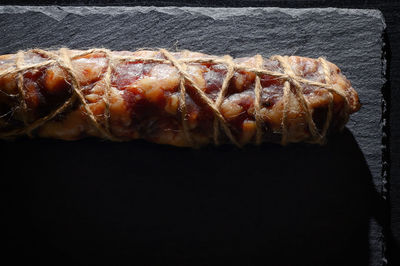Close-up of meat on barbecue grill against black background