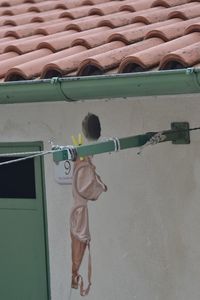 Bra hanging on clothesline against house