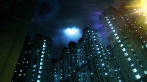 Low angle view of buildings against sky at night