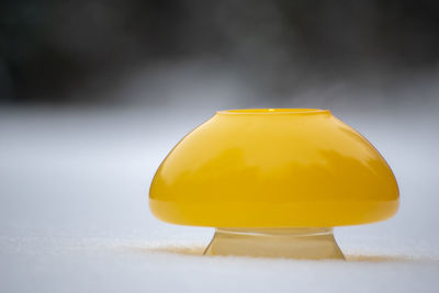 Close-up of yellow glass on table