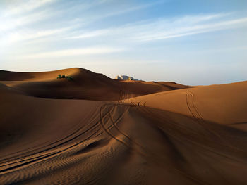 Desert's car tracks, distant mountains - an adventure waiting