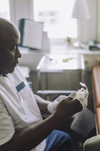 Male healthcare worker wearing gloves in clinic