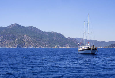 Yacht sailing on aegean sea against clear blue sky