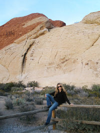 Portrait of a smiling young woman sitting on mountain