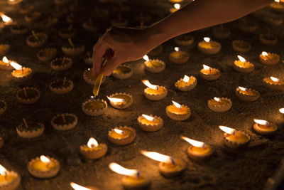 High angle view of hand lighting candles on land