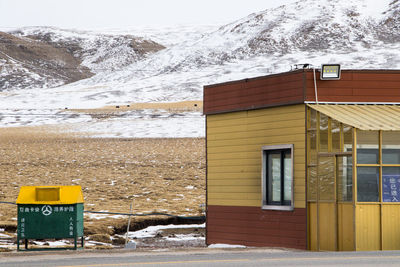 Yellow house on snowcapped mountain during winter