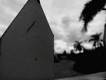 Close-up of cross on cemetery against sky