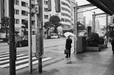 Man walking on street amidst buildings in city