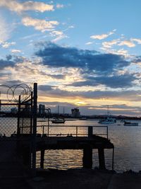 Pier over sea against sky during sunset