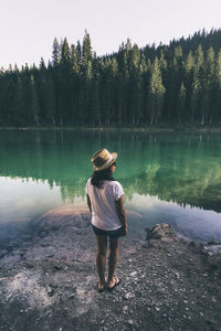 Rear view of woman standing on riverbank