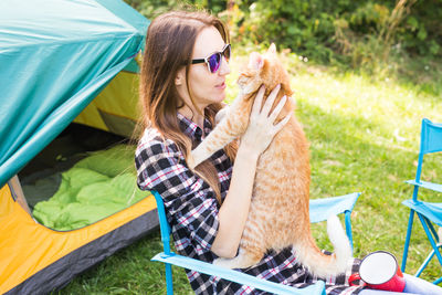 Young woman wearing sunglasses sitting outdoors