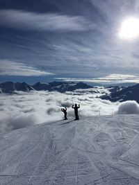 People on snow covered mountain against sky