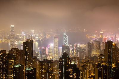 Illuminated cityscape against sky at night