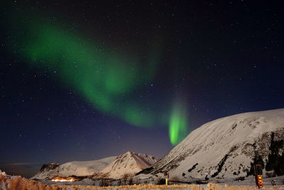 Scenic view of snowcapped mountains against sky at night