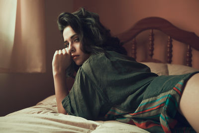 Young woman lying on bed at home