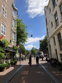 People on street amidst buildings in city
