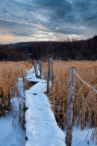 Scenic view of snow covered field against sky