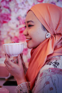 Close-up portrait of woman holding red rose