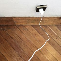 Close-up of electric lamp on hardwood floor against wall