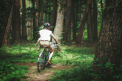 Woman riding bicycle in forest
