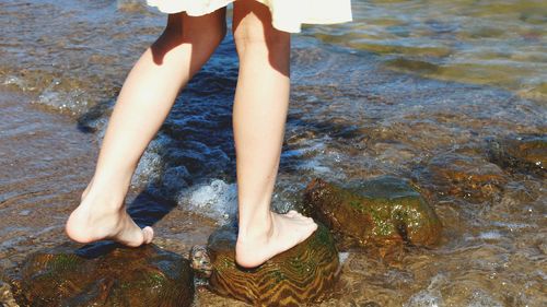 Low section of woman standing on beach