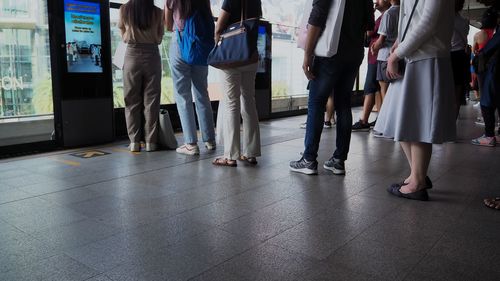 Low section of people standing on tiled floor