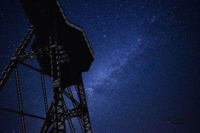 Low angle view of illuminated tower against sky at night