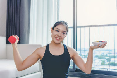 Portrait of smiling young woman holding food