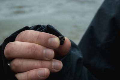 Close-up of hand holding cigarette