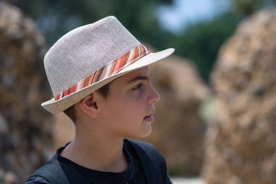 Cute boy wearing hat looking away outdoors