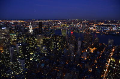 Illuminated cityscape against sky at night
