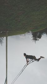 Man standing by tree against sky