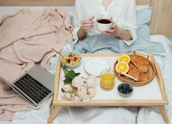 Romantic breakfast with coffee, waffles, orange juice and rose flowers.