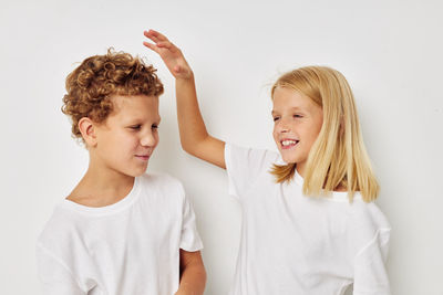 Happy boy and girl against white background