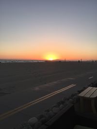 Scenic view of land against clear sky during sunset