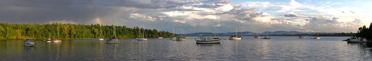 Panoramic view of sailboats moored against sky