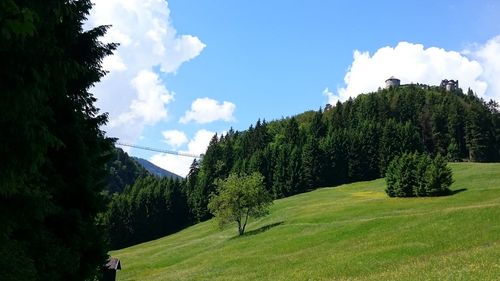 Scenic view of grassy field against cloudy sky