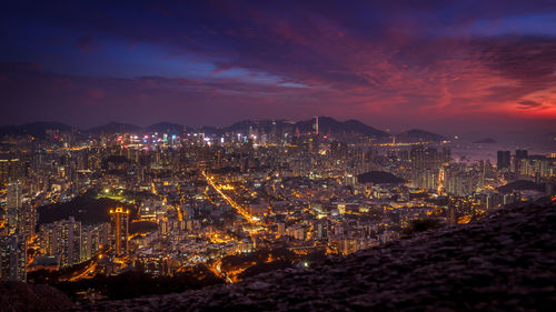 Illuminated cityscape against sky at night