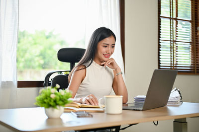 Young woman using laptop at office