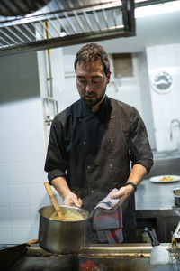 Chef looking down while working at kitchen