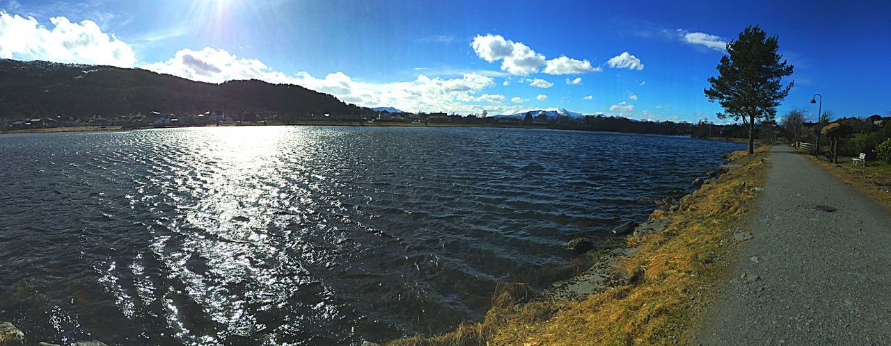 water, sky, tranquil scene, tranquility, mountain, scenics, beauty in nature, lake, cloud - sky, reflection, nature, blue, cloud, rippled, panoramic, idyllic, waterfront, river, mountain range, sunlight