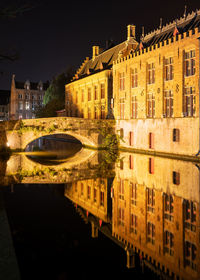 High angle view of canal by buildings in city at night