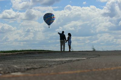 People with umbrella against sky