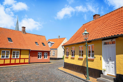 Houses by street against sky in town