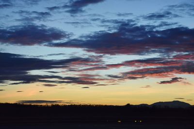 Scenic view of dramatic sky over silhouette landscape