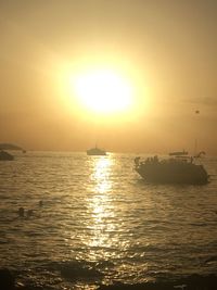 Silhouette boat sailing in sea against sky during sunset